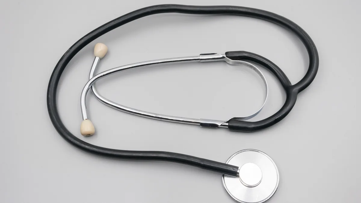 Black stethoscope with silver chest piece on a gray surface, a traditional graduation gift for new nurses