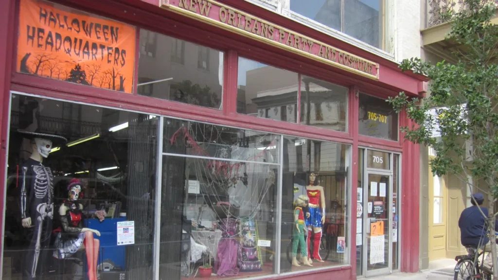 Costume shop front window with skeleton and superhero mannequins under a Halloween headquarters banner