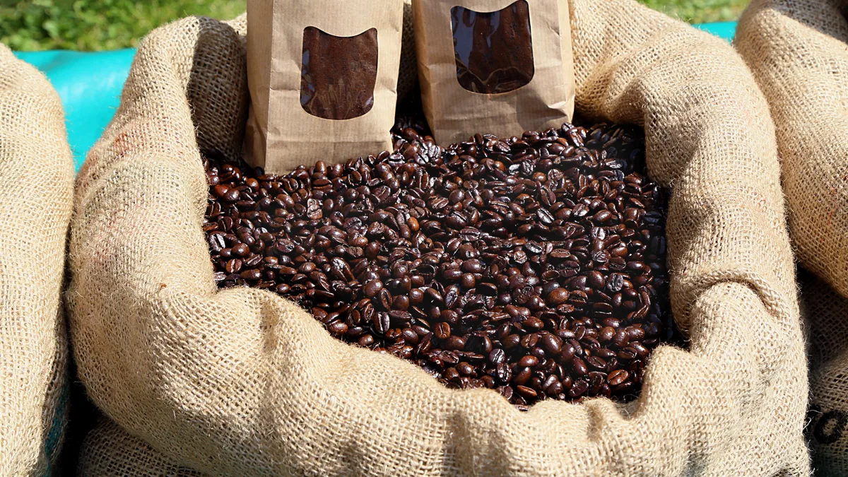 Open burlap sack full of roasted coffee beans with two paper coffee bags, a shareable nurse appreciation gift