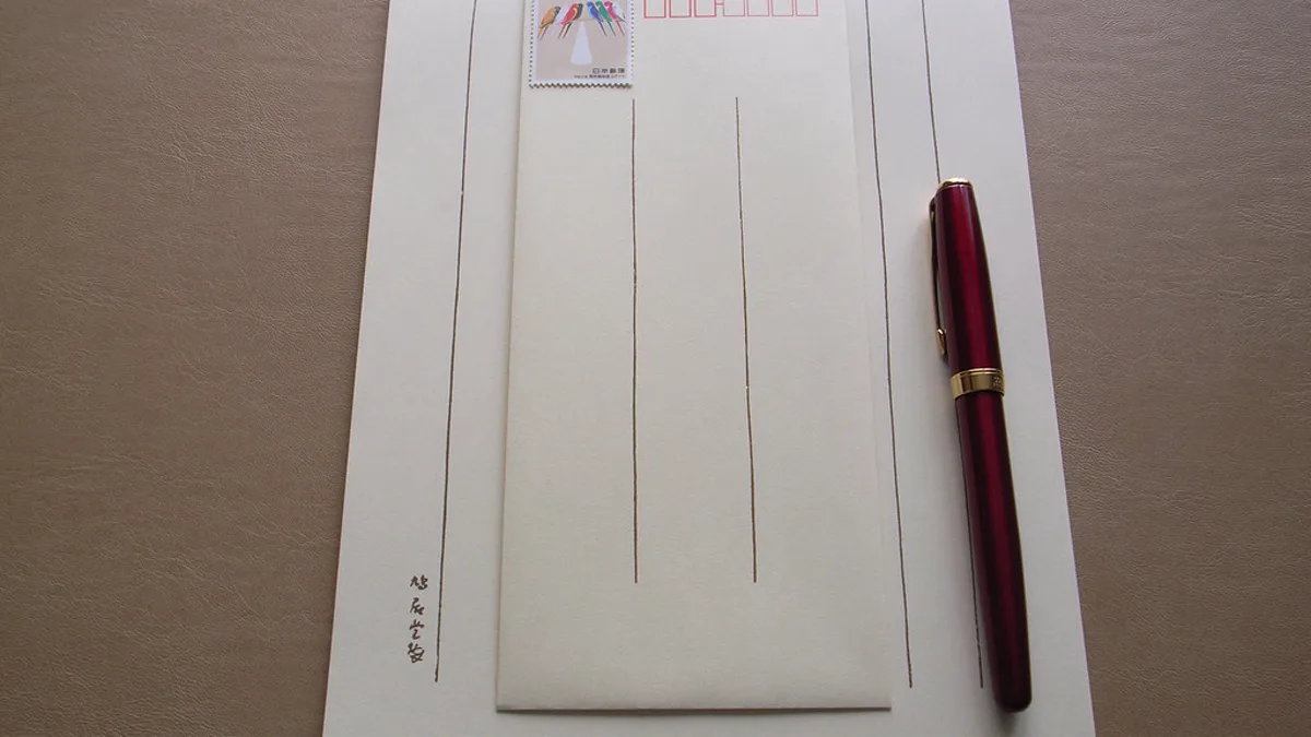 Lined letter paper with a stamped envelope and a red fountain pen for writing a thank you letter to a nurse